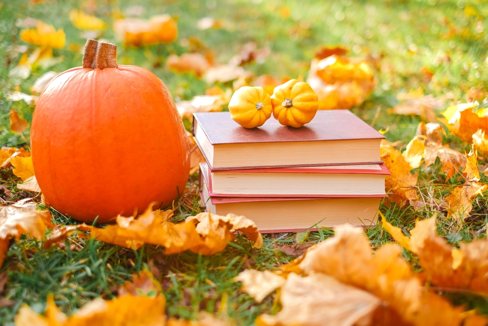 Pumpkin and schoolbooks on leaves